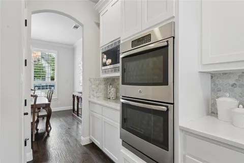 a kitchen with stainless steel appliances a stove a microwave and a hard wood floor