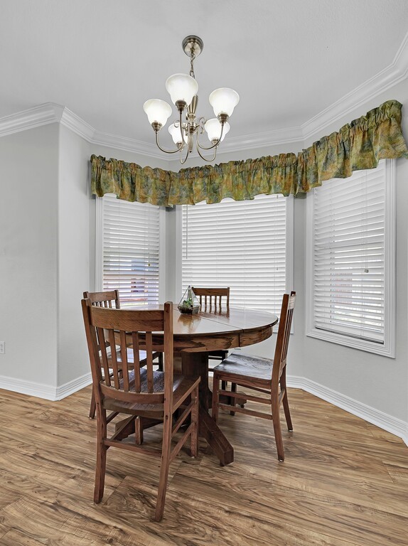 621 South Ruidoso Downs Drive Robinson, TX 76706 - Photo 14 of 41 a view of a dining room with furniture a chandelier and wooden floor