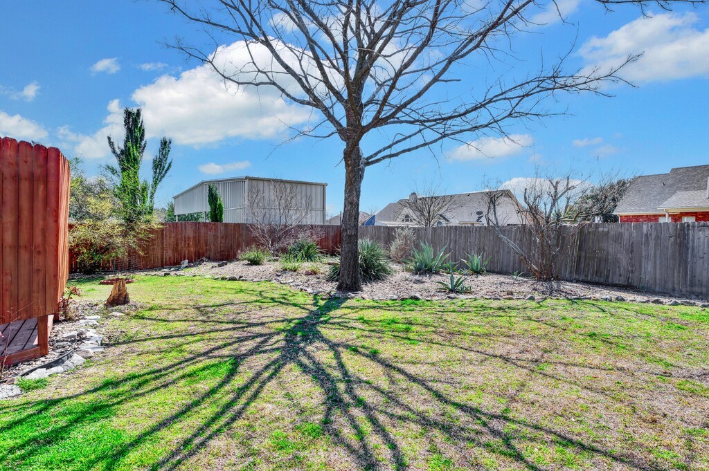 621 South Ruidoso Downs Drive Robinson, TX 76706 - Photo 33 of 41 a white house with a yard and large trees with wooden fence
