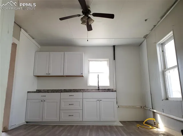 a kitchen with white cabinets granite counter tops and a window