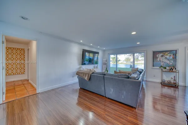 a living room with furniture and a wooden floor