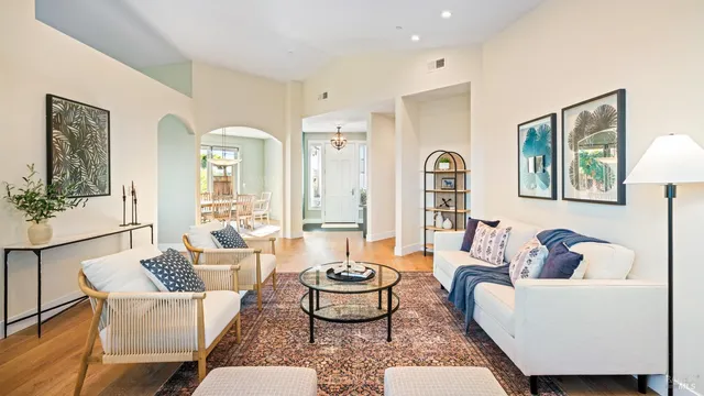 a living room with furniture a clock and a large window