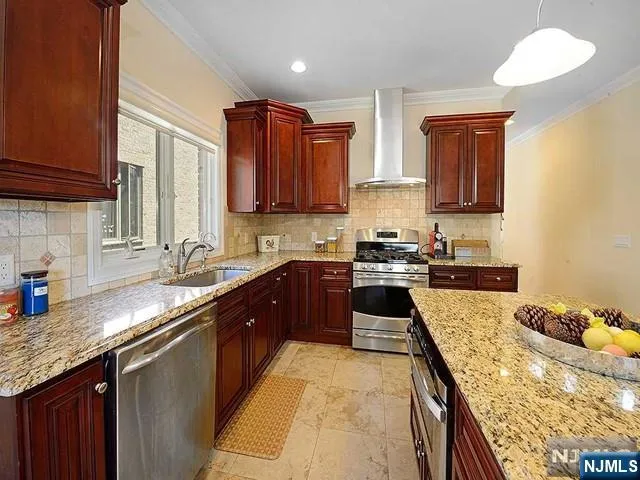 a large kitchen with granite countertop a sink a counter space and cabinets