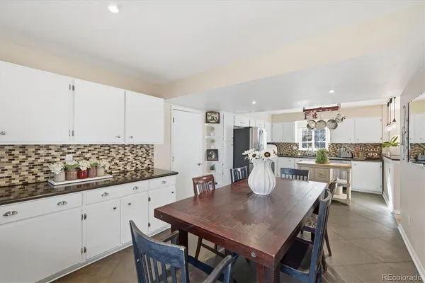 a kitchen with stainless steel appliances kitchen island granite countertop a table and chairs