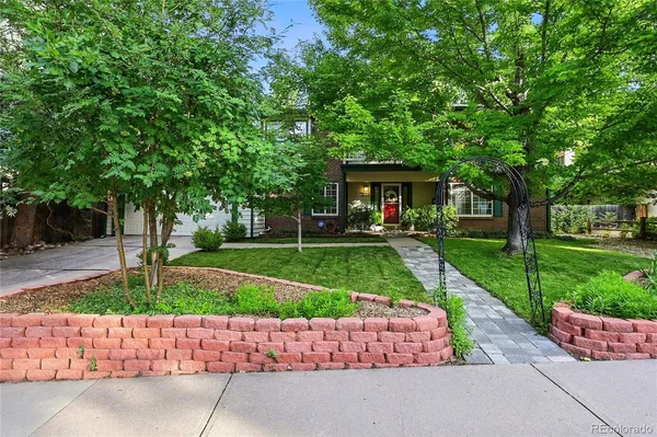 a front view of a house with a yard and a garden
