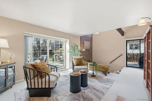a living room with furniture a window and potted plants
