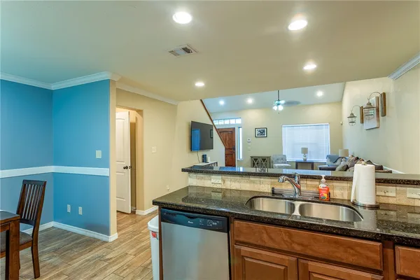 a kitchen with a sink and wooden floor