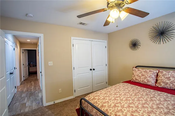 a bedroom with a bed and a chandelier fan
