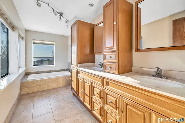 a bathroom with a tub sink and mirror