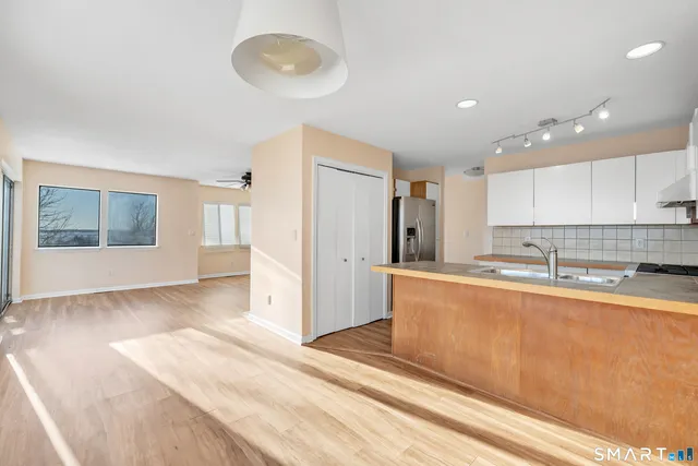 a large kitchen with stainless steel appliances granite countertop a refrigerator and a stove top oven