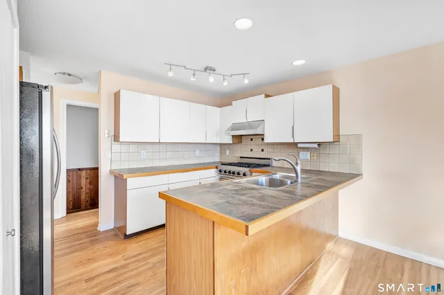 a kitchen with stainless steel appliances granite countertop a sink stove and refrigerator