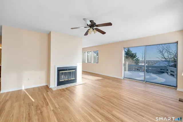 a view of empty room with wooden floor and fireplace