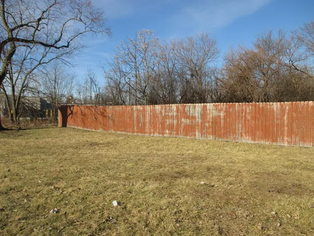 a view of backyard with wooden fence