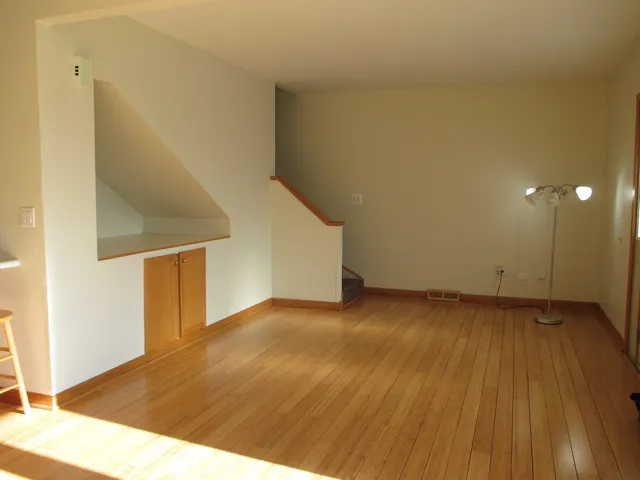a view of an empty room with wooden floor