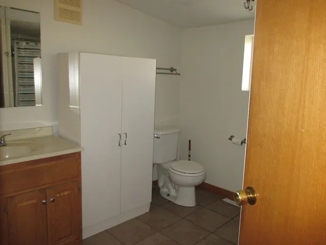 a bathroom with a granite countertop toilet a sink and a mirror