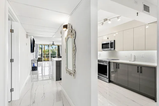 a open kitchen with white cabinets and stainless steel appliances