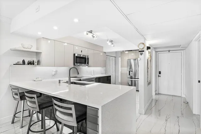 a kitchen with kitchen island a stove a table and chairs in it