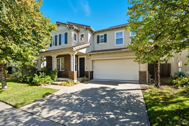 a front view of a house with yard and green space