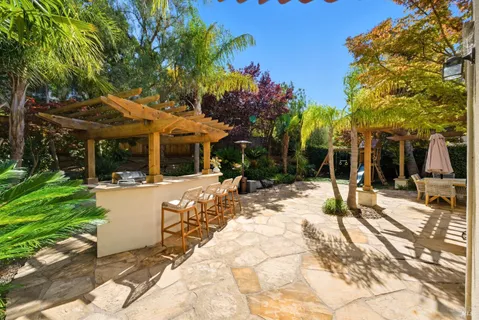 a view of a patio with a table and chairs under an umbrella
