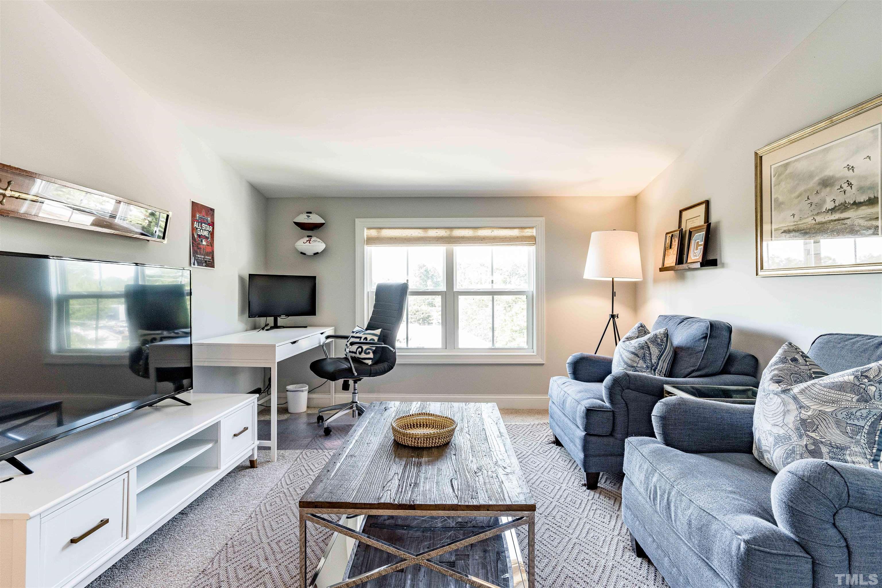 6801 Milligan Way, Unit 107 Raleigh, NC 27613 - Photo 22 of 27 a living room with furniture and a flat screen tv