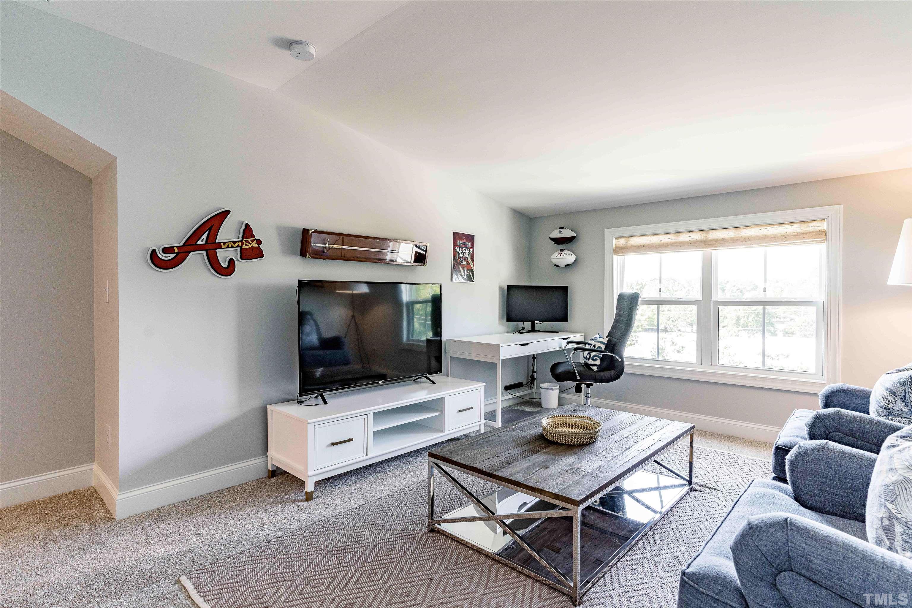 6801 Milligan Way, Unit 107 Raleigh, NC 27613 - Photo 23 of 27 a living room with furniture a flat screen tv and a window