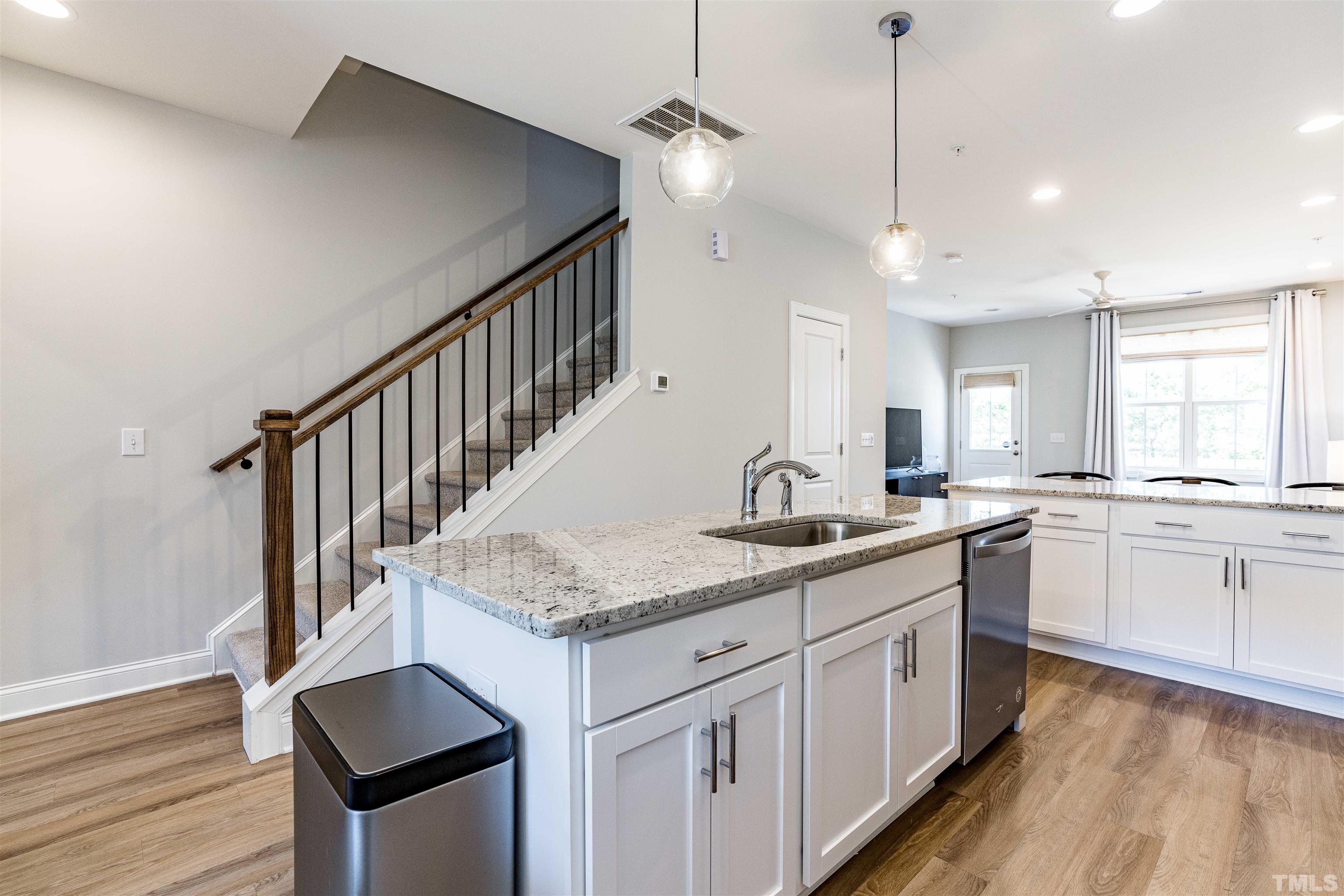 6801 Milligan Way, Unit 107 Raleigh, NC 27613 - Photo 5 of 27 a kitchen with sink cabinets and wooden floor