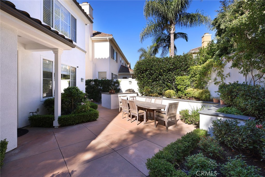 9 Chaminade Newport Coast, CA 92657 - Photo 24 of 29 a view of a patio with table and chairs potted plants and palm tree