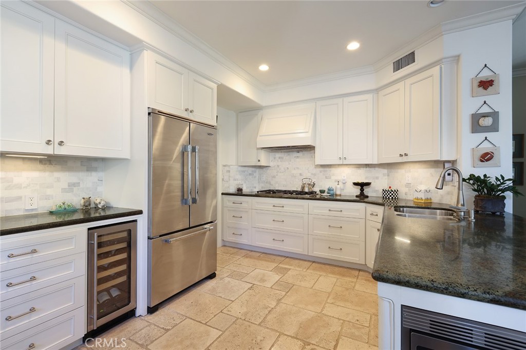 9 Chaminade Newport Coast, CA 92657 - Photo 6 of 29 a kitchen with granite countertop a refrigerator sink and cabinets