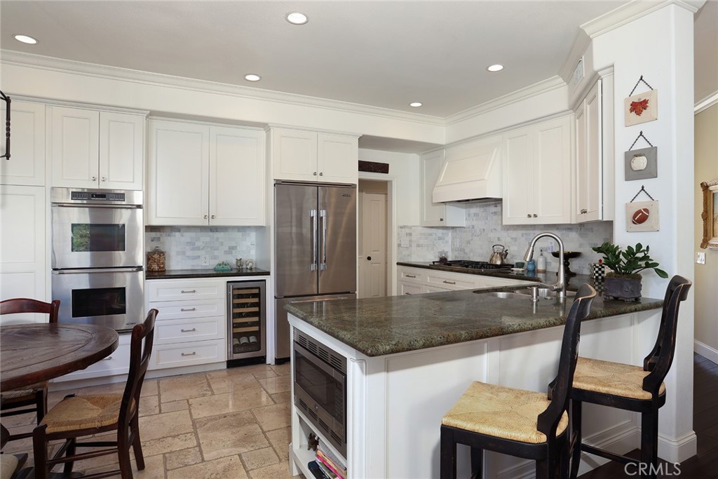 9 Chaminade Newport Coast, CA 92657 - Photo 7 of 29 a kitchen with a refrigerator a stove a sink and chairs
