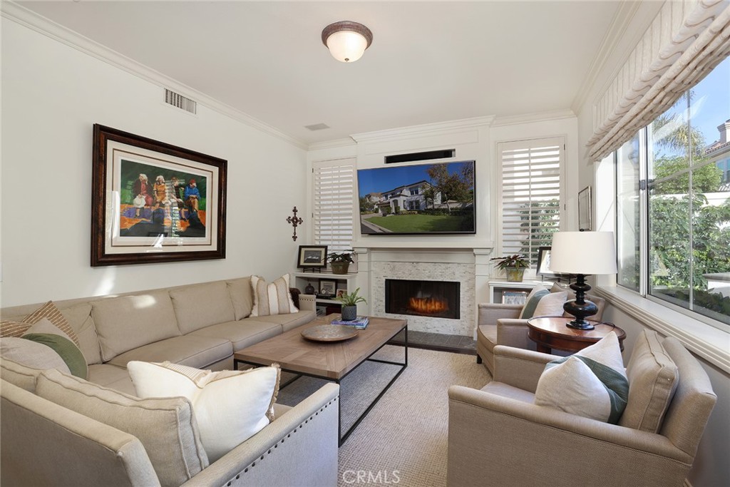 9 Chaminade Newport Coast, CA 92657 - Photo 9 of 29 a living room with furniture a flat screen tv and a fireplace