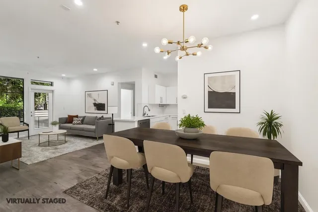 a living room with furniture a chandelier and a dining room