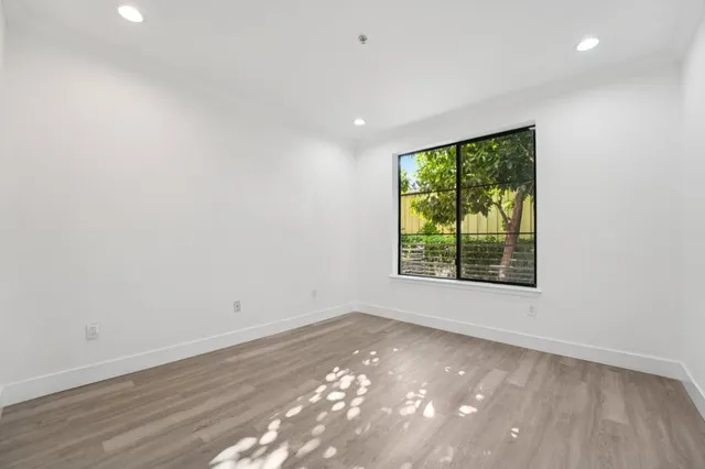an empty room with wooden floor and windows