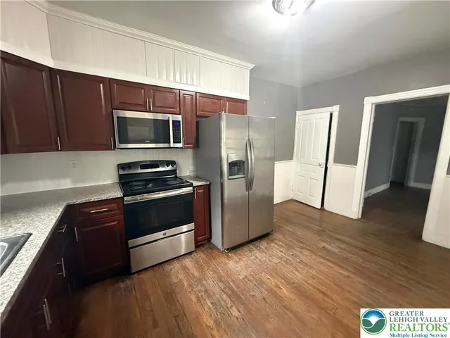 a kitchen with granite countertop wooden cabinets and stainless steel appliances