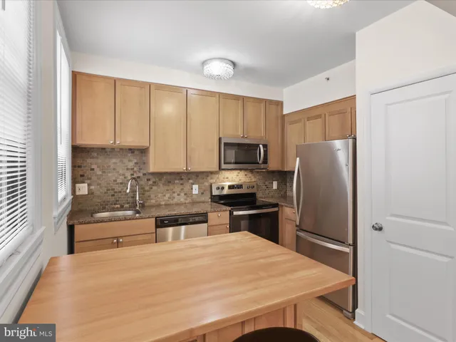 a kitchen with granite countertop a sink a stove and cabinets