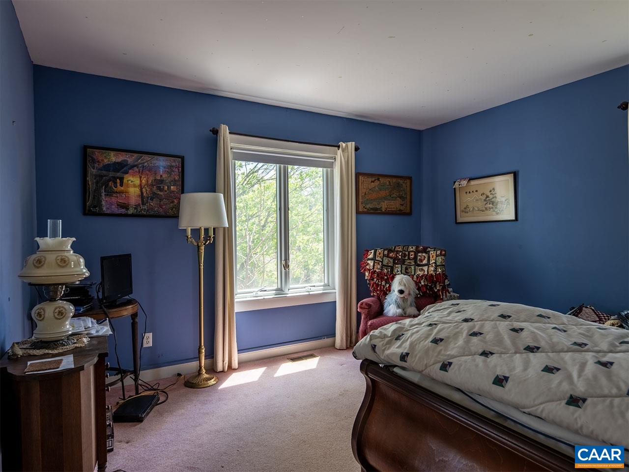 7230 Plank Road Afton, VA 22920 - Photo 19 of 37 a bedroom with a bed and a flat tv screen on the dresser
