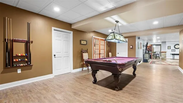 a room with pool table and windows