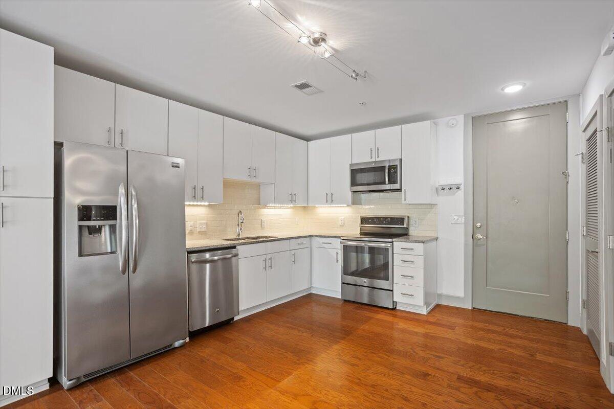1300 St Marys Street, Unit 207 Raleigh, NC 27605 - Photo 3 of 31 a kitchen with granite countertop a refrigerator stove and oven