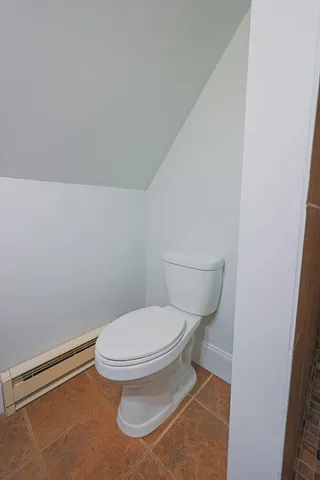 a white toilet sitting next to a white wall