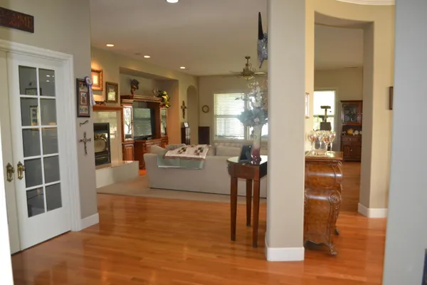 a dining room with furniture a chandelier and wooden floor
