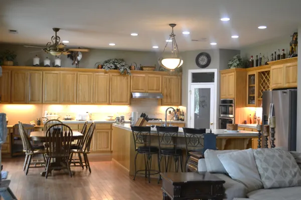 a view of an empty room with wooden floor and cabinets