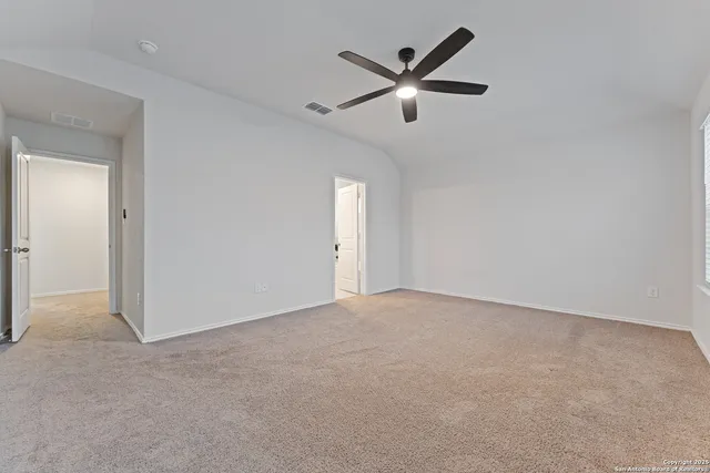 an empty room with a ceiling fan and window
