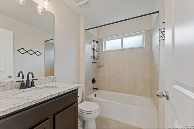 a bathroom with a granite countertop sink a toilet and shower