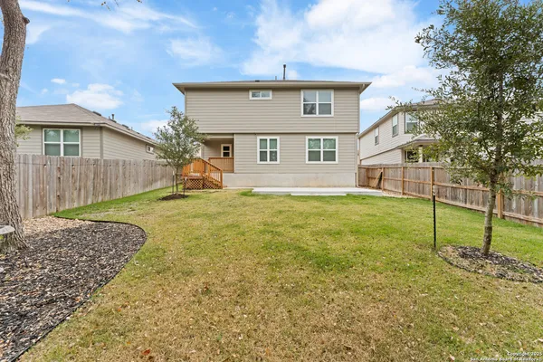 a view of a big house with a big yard and large tree