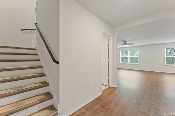 a view of an empty room with wooden floor and windows