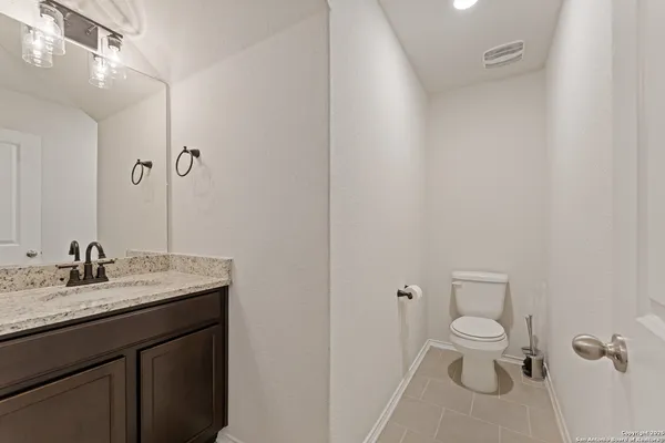 a bathroom with a granite countertop sink toilet and mirror