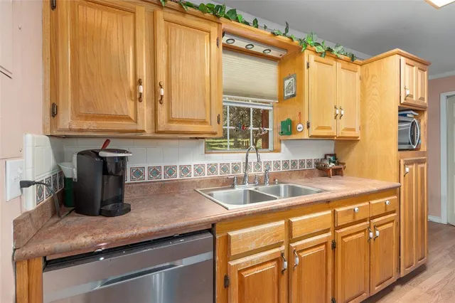 a kitchen with stainless steel appliances granite countertop a sink a refrigerator and cabinets with wooden floor