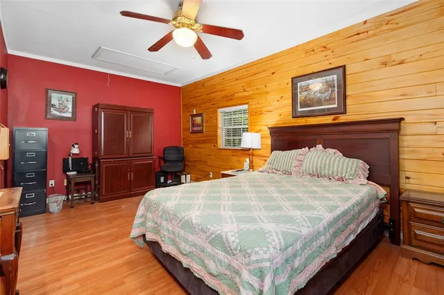 a bedroom with a bed and wooden floor