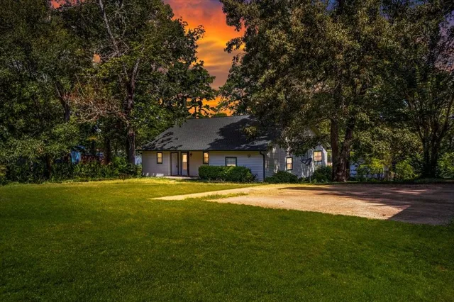 a yellow house with trees in front of it