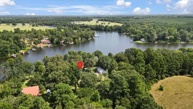 an aerial view of residential houses with outdoor space and lake view