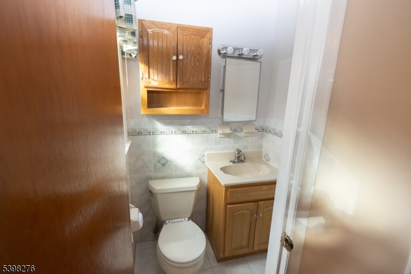 169 Valley View Road Hillside, NJ 07205 - Photo 15 of 32 a bathroom with a toilet sink and mirror